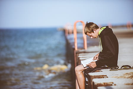 man reading books sitting on dock thumbnail