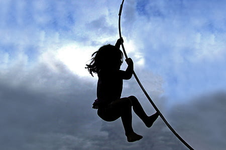 silhouette of child holding on rope thumbnail