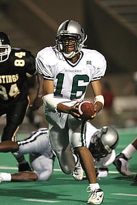 football player holding brown football thumbnail