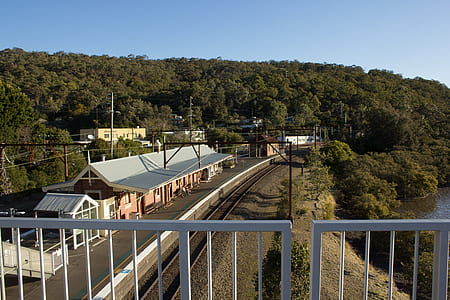 beige and white concrete house near train track during daytime thumbnail