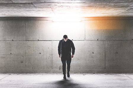 Young Man Walking in Conrete Underground Walkway thumbnail