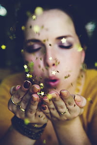 woman wearing yellow shirt blowing water glitters thumbnail