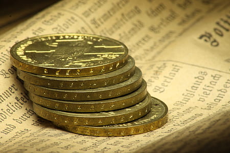round silver-colored coins on top of newspaper thumbnail
