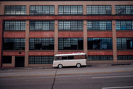 beige vehicle parked in front of brown building thumbnail