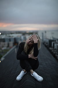 woman wearing black long-sleeved shirt siting on the roof thumbnail