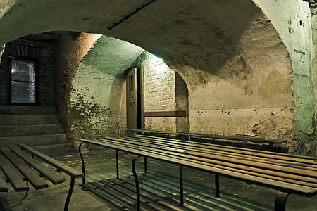 brown wooden bench under arch concrete pillar at nighttime thumbnail