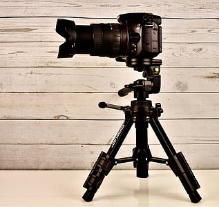 black DSLR camera on top of tripod thumbnail
