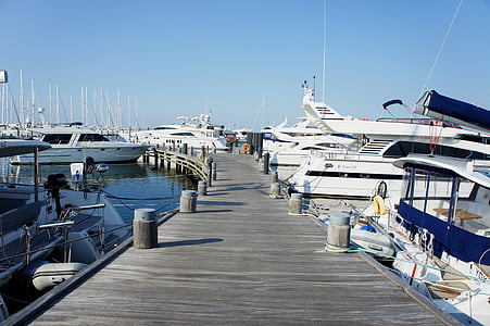 gray dock with yachts under blue sky during daytime thumbnail