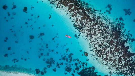 person on body of water near island thumbnail