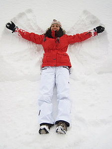 woman in red coat and pants lying on snow field thumbnail