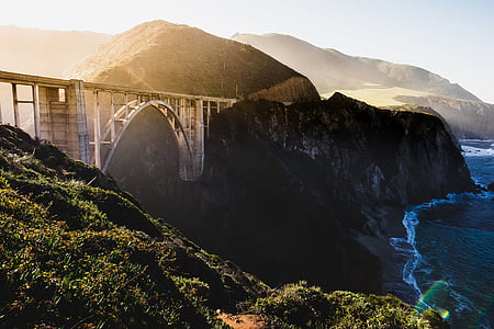 bridge beside of mountain cliff during daytime thumbnail