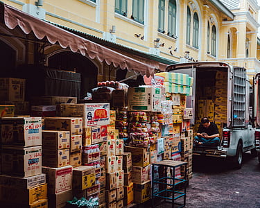 man on back of pickup truck with assorted cardboard boxes outdoors during day thumbnail
