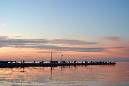 silhouette of people at dock during golden hour thumbnail