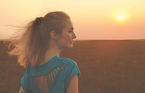 woman wearing blue crew-neck shirt standing facing sun thumbnail