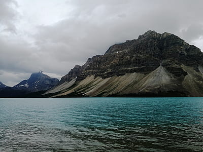 mountain and body of water under black sky thumbnail