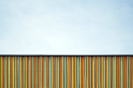 orange, teal, and yellow wooden fence at daytime thumbnail