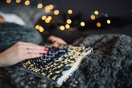 Young woman at home reading Hygge book and drinking thumbnail