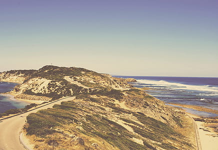 asphalt road on top of mountain beside body of water thumbnail