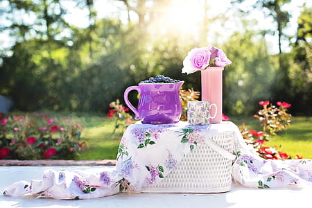 purple ceramic pitcher on white wicker picnic basket during daytime thumbnail