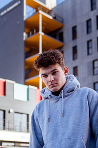 shallow focus photography of man standing near building thumbnail