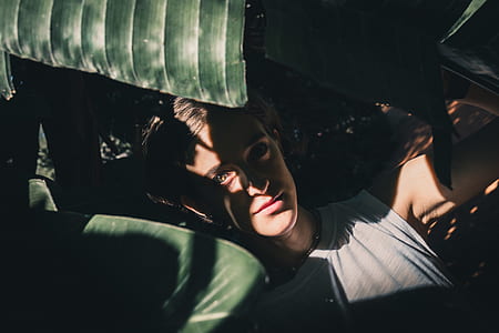 man lying under plants thumbnail