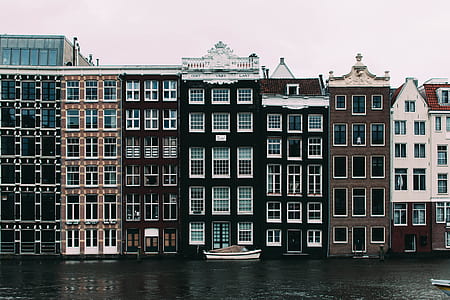 White Sailboat Beside Concrete Building thumbnail