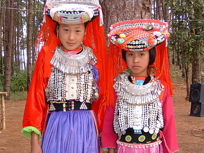 two girl's wearing red-and-gray long-sleeved traditional dresses thumbnail