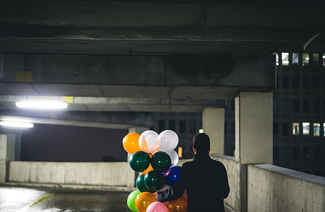 person holding assorted-color balloons thumbnail