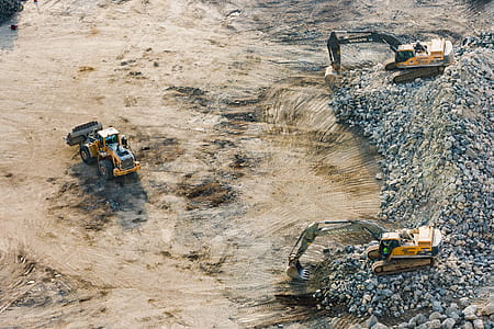 Three Yellow Excavators Near Front End Loader thumbnail