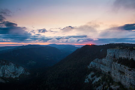 landscape photography of mountains under cloudy sky thumbnail