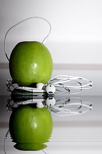 close-up photo of green apple fruit beside white Apple EarPods thumbnail