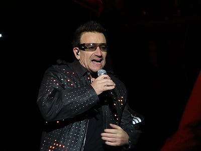 man holding microphone wearing black leather jacket performing on stage thumbnail