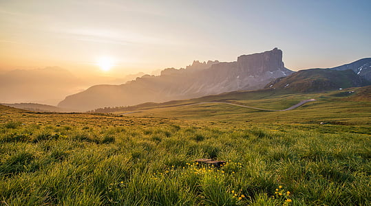 green grass field near mountain at daytime thumbnail