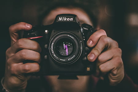 person holding black Nikon DSLR camera thumbnail