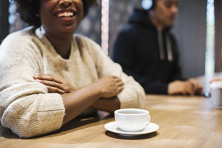 smiling woman sitting beside table inside room thumbnail