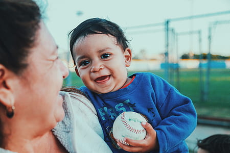 smiling toddler holding baseball thumbnail