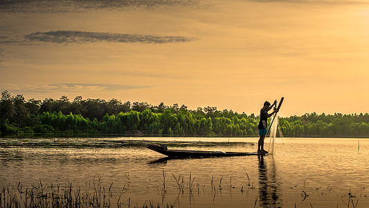 man on boat holding fish net thumbnail