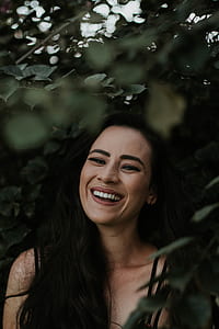 woman smiling surrounded by green leaves thumbnail