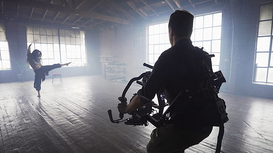 man holding video camera shooting woman dancing thumbnail