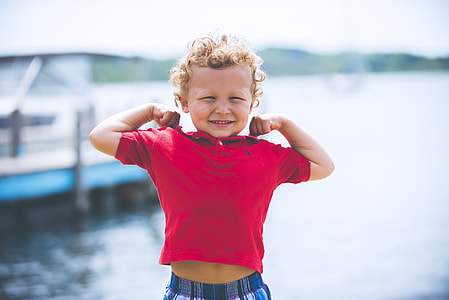 boy stretching his arms near body of water thumbnail