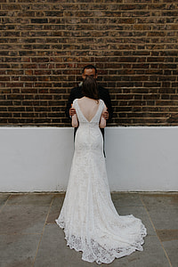 man holding arm of woman in wedding dress thumbnail