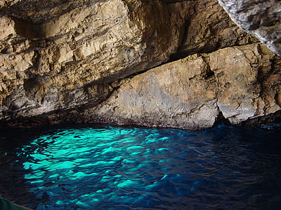 cave with body of water during daytime thumbnail