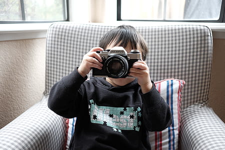 boy sitting holding SLR camera talking photo thumbnail