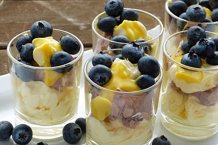 ice creams with berries on top in clear glasses thumbnail
