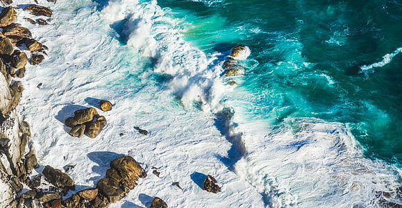 aerial photo of body of water and rock formation thumbnail