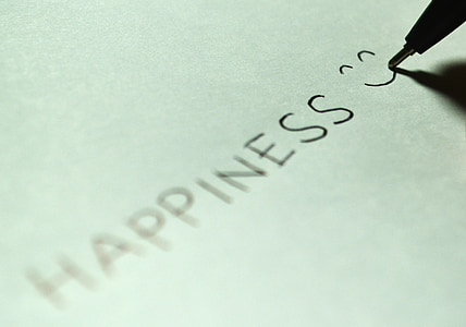 person writes happiness with smiley thumbnail