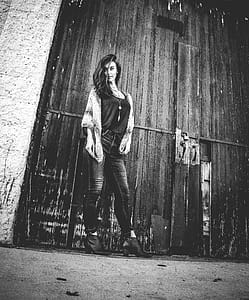 Gray Scale Woman Standing Near Door thumbnail