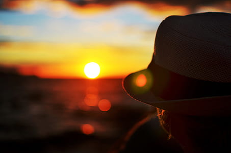 person wearing gray hat during sunset thumbnail