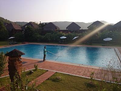 person standing beside swimming pool during daytime thumbnail