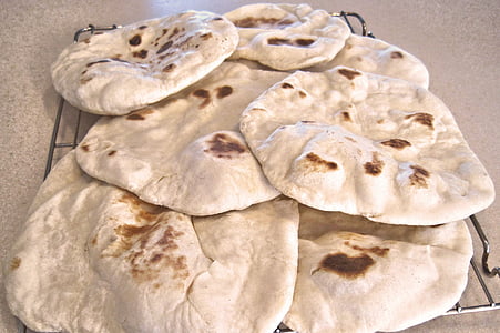 seven pita breads on gray steel rack thumbnail